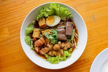 Savory Delight: Top-down shot of a delicious bowl of noodles artfully arranged, capturing the eye with its vibrant presentation and rich flavors.