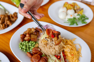 Exquisite Culinary Display: A hand delicately garnishes a vibrant plate of rice, inviting the viewer on a visual journey through a variety of textures and flavors.