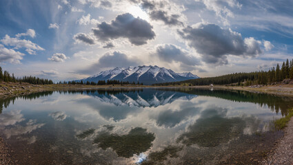 Obraz premium Stunning Panoramic Reflection of Snow Capped Mountains and Forest in Lake