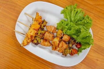 Grilled Skewers with Fresh Salad: a close-up shot of vibrant skewers of grilled food and fresh salad sitting on a plate
