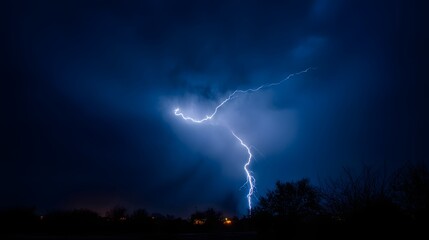 Naklejka premium A dramatic lightning strike illuminating dark storm clouds at night