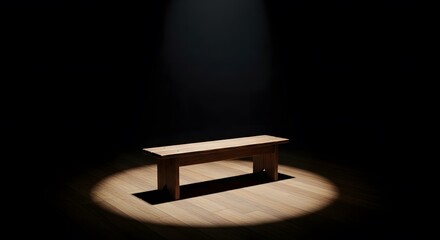 A solitary wooden bench illuminated by a spotlight in a dark room.