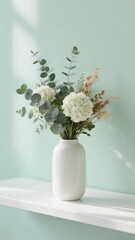 Fototapeta premium White vase with dried flowers and eucalyptus on a shelf against a light blue wall