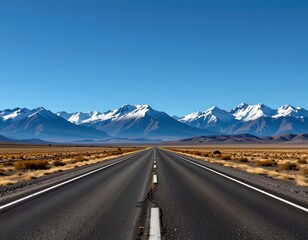 Fototapeta premium Long Road Leading Snowcapped Mountain Range