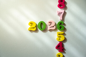 Colorful Wooden Numbers 2026 with Shadows and Light Patterns