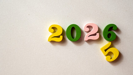 Colorful Wooden Numbers 2025 and 2026 on Light Background