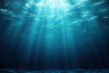 Sunlight beams penetrating deep into the calm underwater ocean with a blue gradient and visible water surface