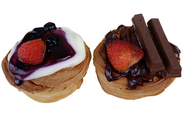 Delightful sweet pastry buns offer tempting dessert. Each bun features fresh strawberry. One has creamy topping with rich blueberry jam, other includes chocolate biscuit sticks