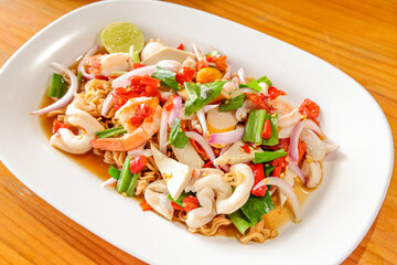 Delicious Seafood Salad: A mouthwatering close-up of a fresh seafood salad with vibrant colors, featuring succulent shrimp, squid, and flavorful seasonings, served on a pristine white plate.