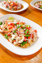 Seafood Salad: A vibrant culinary composition, showcasing a beautifully arranged seafood salad on a bright, modern plate, with appetizing fresh ingredients on a wooden surface. 