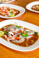 Exquisite Shrimp Dish: An overhead shot of plates showcases a gourmet shrimp dish in a rich, flavorful sauce, garnished with fresh ingredients, inviting culinary exploration.