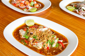 Seafood Culinary Delight: An exquisite tableau of culinary artistry unfolds, showcasing three distinct seafood dishes, each meticulously plated and garnished with fresh herbs and vibrant citrus.