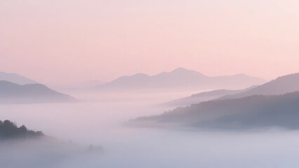 Fototapeta premium Misty mountain landscape at dawn with soft pink sky and layered fog covering valleys