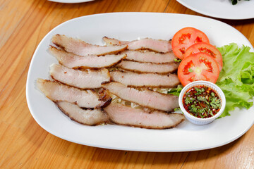 Grilled Meat Dish: A delectable culinary composition features expertly grilled slices of savory meat, artfully arranged on a pristine white plate, alongside vibrant tomato slices, fresh lettuce.