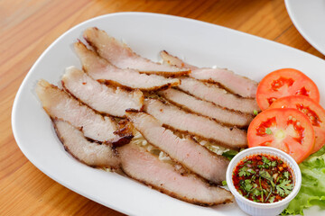 Grilled Pork Collar on Plate: a vibrant shot showcasing expertly grilled pork collar, beautifully presented on a pristine plate, and artfully garnished with fresh tomato slices.