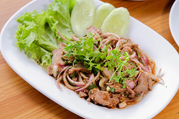 Spicy Thai Salad: A tantalizing overhead shot showcasing a traditional Thai salad with marinated meat, mixed with vibrant herbs and vegetables and cucumber, artfully arranged on a pristine plate. 