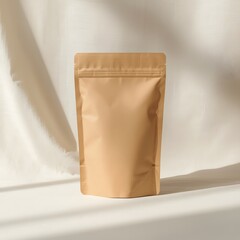 Minimal mockup of blank brown kraft paper pouch standing on soft fabric draped background, eco friendly packaging design template for branding, product presentation and natural concept style