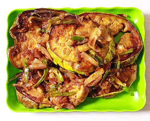 Deliciously seasoned fried eggplant slices on a green plate.