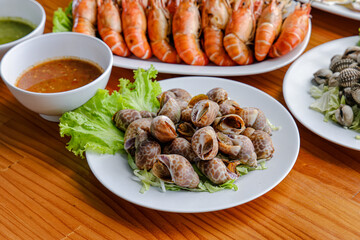 Seafood Platter: A mouthwatering assortment of freshly cooked seafood delicacies, including succulent prawns, shellfish, and snails, artfully arranged for a visual and gastronomic treat.