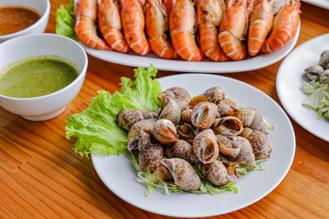 Seafood feast: A culinary arrangement of cooked seafood dishes on a wooden table, showcasing the freshness and variety of the sea's bounty.