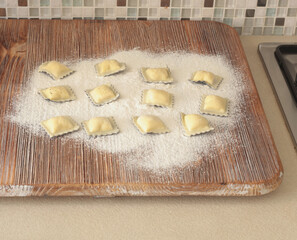 Homemade ravioli with fish and cuttlefish ink on wooden board. Traditional food, Italy. Healthy eating and organic products.