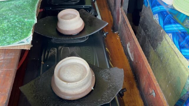 The process of making "Surabi" cake using a special pan and covered with clay pottery.