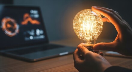 Person holding a glowing light bulb with digital circuit pattern and laptop
