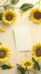 A flat lay of Several sunflowers and leaves surrounding a blank card on a pale beige background.