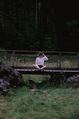 Mujer sentada en muelle cerca de las monta&ntilde;as