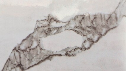 A close-up of marble with distinctive grey veining on a white background, creating a unique, natural pattern.