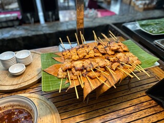 Freshly grilled Thai pork skewers served on banana leaf a popular street food dish often enjoyed with dipping sauce