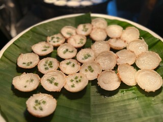 Thai coconut pancakes known as Khanom Krok served on a banana leaf with green onion topping traditional Asian street food