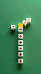 Abstract arrangement of white and yellow directional blocks with arrows on a green surface.