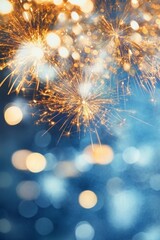 Sparkling fireworks with golden sparks against a blue bokeh background