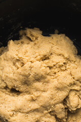 Nigerian Chin chin dough in a black mixing bowl, Raw chin-chinbeing mixed, process of making chin chin achomo or klenat	