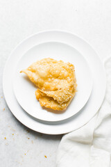 Overhead view of dublan northern nigerian snack, top view of dublan on a plate, flaky fried dough coated in syrup and sesame