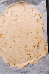 Overhead view of fire crackers dough on parchment paper, top view of spicy cracker dough, process of making fire crackers