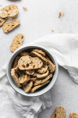 top view of bread crisps in a white bowl, Overhead view of toasted bread chips on white background