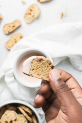 overhead view of slices of savory biscotti with dip, top view of thinly sliced bread chips with sauce, top view of crostini bread slices on marble countertop