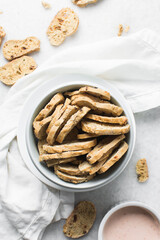 top view of bread crisps in a white bowl, Overhead view of toasted bread chips on white background