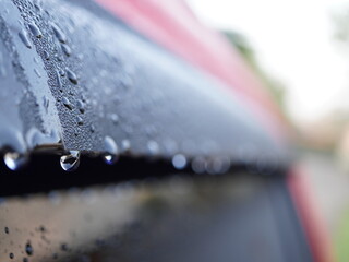 Captivating close-up of glistening water droplets on a dark, reflective surface, evoking freshness...
