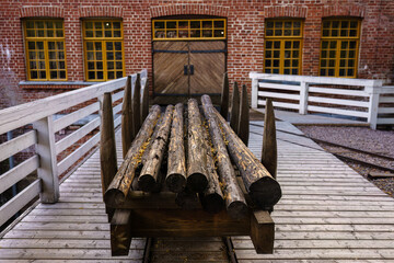 Wooden logs stacked on an old railroad cart outside Verla Mill Museum in Jaala, FInland
