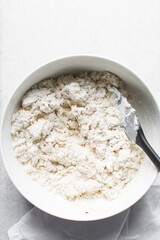 overhead view of savory biscotti dough in a bowl, top view of savory cookie dough in a mixing bowl