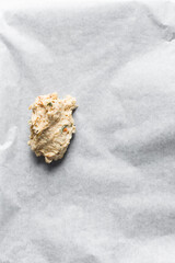 overhead view of savory biscotti dough on a parchment lined baking sheet, top view of savory cookie dough on parchment paper