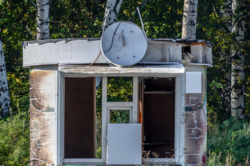 An abandoned shopping kiosk in a city park on an autumn day