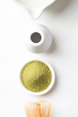 Top view of matcha green tea powder with bamboo whisk and Chawan bowl on white background
