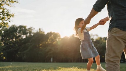 Shot of an excited little girl being spun around in the air by her unidentifiable father - Powered by Adobe