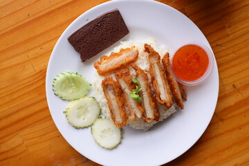 Crispy Chicken Rice Dish: A culinary masterpiece of perfectly cooked rice topped with succulent, crispy chicken and accompanying garnishes, photographed in detail.