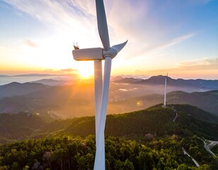 Wind turbine atop mountain range at sunrise