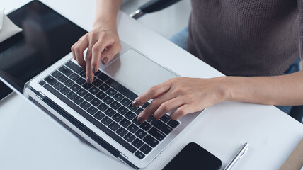 Close up of business woman hands working, typing on laptop computer keyboard, surfing the internet...